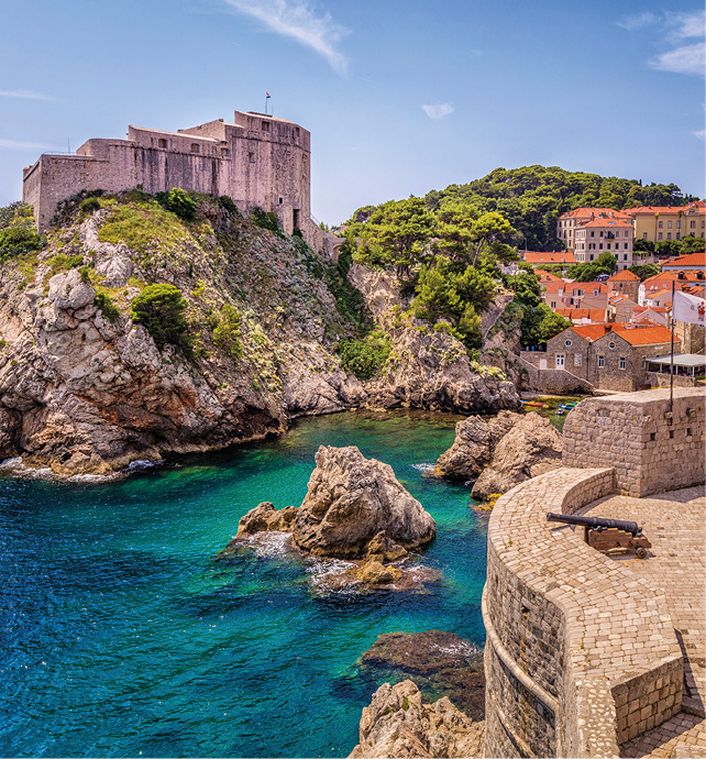 A view over Dubrovnik, Croatia showing red roofs and buildings set atop large rocks. 