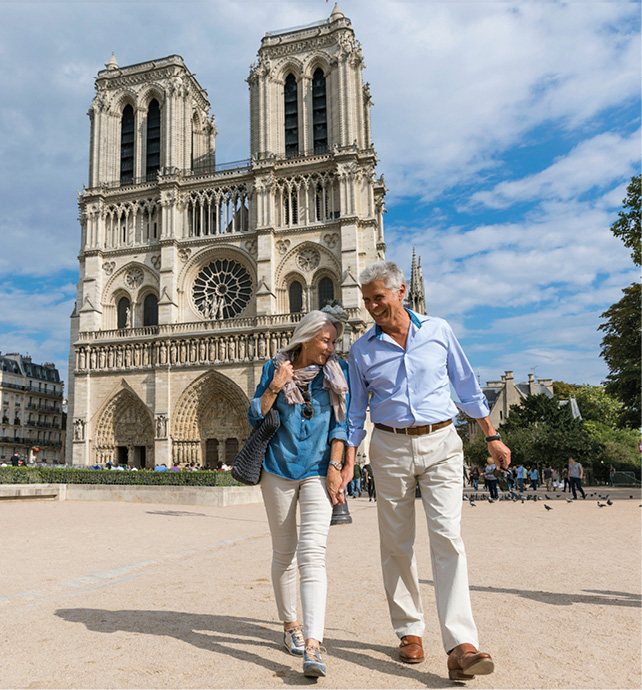 Couple exploring the city of Paris, France, walking past a Gothic church